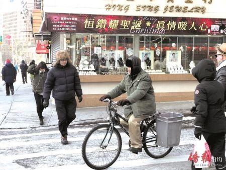 　天寒地冻，华人外卖郎的身影出现在华埠街头。(美国《侨报》陈辰摄)
