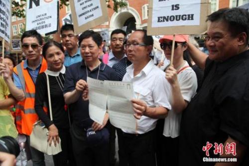 伦敦华埠商会主席邓柱廷(前左3)等侨领在展示致英国内政部的申诉信函。 <a target='_blank' >中新社</a>记者 张平 摄 ..