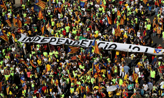 在巴塞罗那9月11日的游行中，民众高举巨大“独立”横幅。（图片来源：路透社）